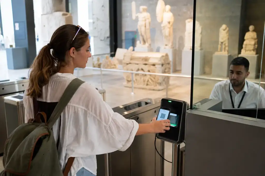 Посетитель показывает QR-код музейной карты на смартфоне у входа в музей в Турции